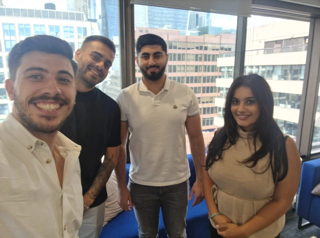 Charles Kyriakou smiling with three recruiters in office